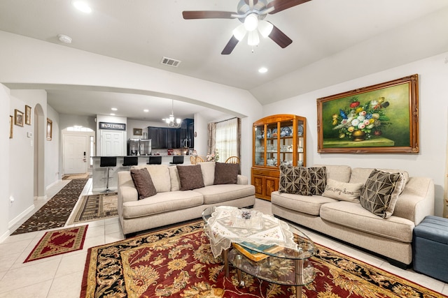 living area with arched walkways, a ceiling fan, light tile patterned floors, recessed lighting, and vaulted ceiling