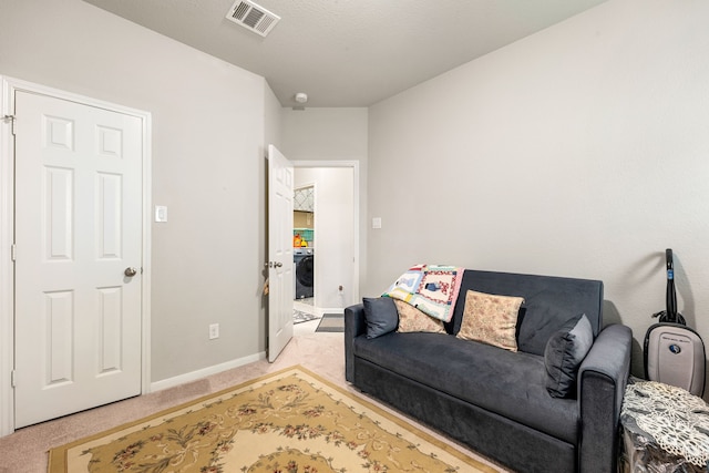 carpeted living room with baseboards and washer / dryer