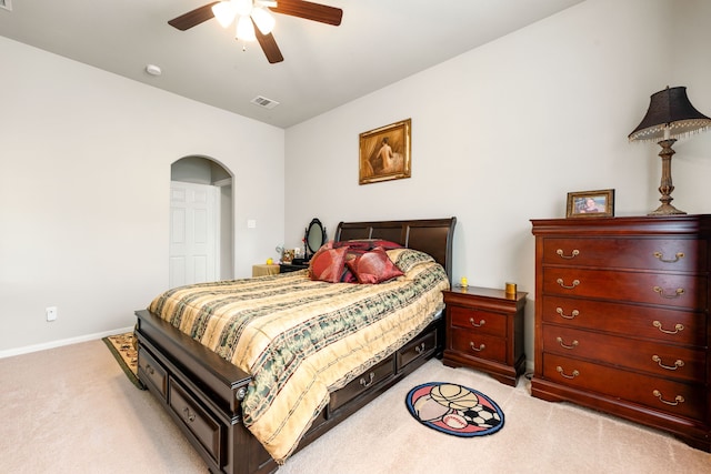 bedroom with light carpet, baseboards, arched walkways, and ceiling fan