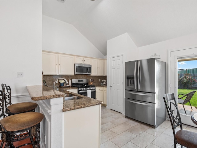 20118 Lakespire Dr, Katy, TX 77449 - kitchen featuring stainless steel appliances, a sink, a peninsula, decorative backsplash, and dark stone counters