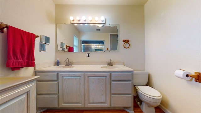 full bath featuring toilet and double vanity