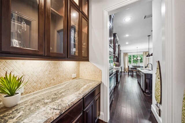 18 Star Iris Pl, Tomball, TX 77375 - kitchen featuring dark brown cabinets, light stone countertops, dark wood finished floors, and recessed lighting