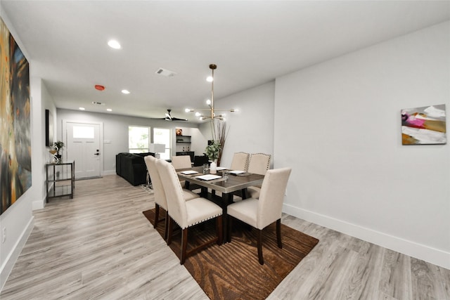 dining room featuring light wood finished floors, baseboards, and recessed lighting
