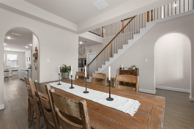 2510 Ocean Key Dr, Texas City, TX 77568 - dining area featuring arched walkways, wood finished floors, baseboards, stairway, and recessed lighting