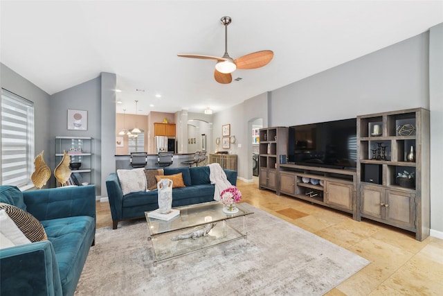 living room featuring arched walkways, a ceiling fan, and baseboards
