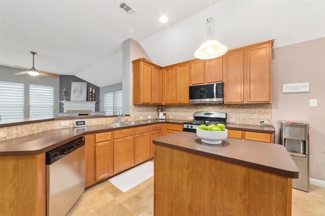 kitchen with appliances with stainless steel finishes, a sink, dark countertops, vaulted ceiling, and decorative backsplash