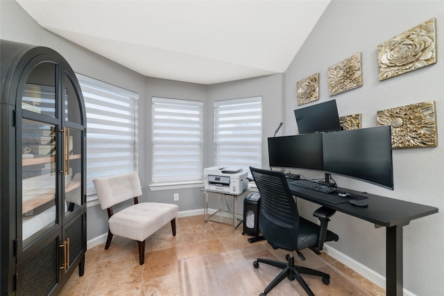 office space featuring healthy amount of natural light, baseboards, and vaulted ceiling
