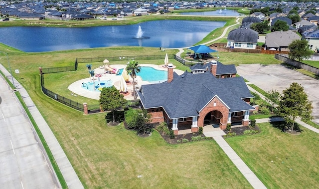 aerial view of residential area featuring a nearby body of water and a pool area