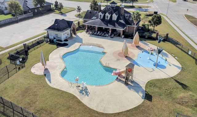 community pool with a water slide and a patio