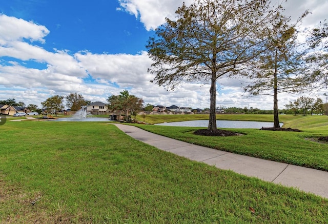 view of community featuring a water view and a lawn