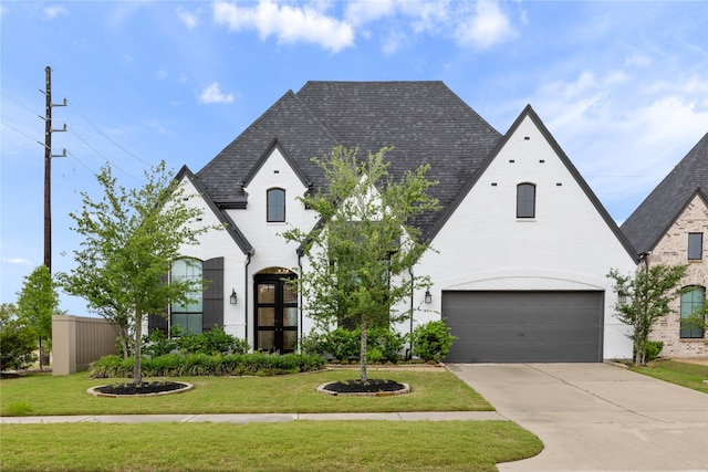 4826 Hudson Park Ct, Fulshear, TX 77441 - french country inspired facade featuring a front lawn, a garage, driveway, a shingled roof, and brick siding