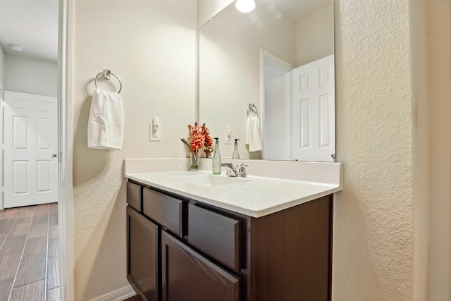3519 Barkers Run Dr, Houston, TX 77084 - bathroom with a textured wall, vanity, wood finished floors, and baseboards