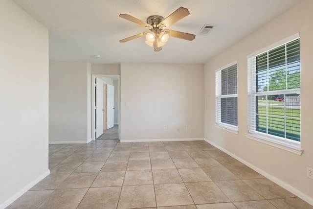 unfurnished room featuring a ceiling fan, light tile patterned floors, and baseboards