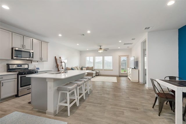 502 Rain Cloud Dr, Baytown, TX 77523 - kitchen featuring stainless steel appliances, a sink, gray cabinetry, open floor plan, and recessed lighting