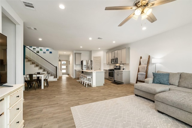 502 Rain Cloud Dr, Baytown, TX 77523 - living room featuring stairway, a ceiling fan, light wood finished floors, recessed lighting, and baseboards