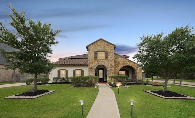 5502 Charlton Ridge Ln, Fulshear, TX 77441 - view of front facade featuring a tiled roof, stone siding, a yard, and stucco siding