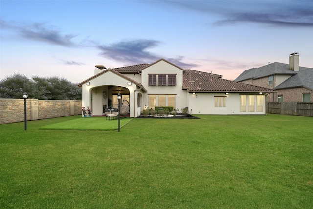 5502 Charlton Ridge Ln, Fulshear, TX 77441 - back of house at dusk with stucco siding and a chimney