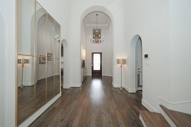 5502 Charlton Ridge Ln, Fulshear, TX 77441 - entrance foyer with a high ceiling, arched walkways, dark wood-style floors, a chandelier, and baseboards
