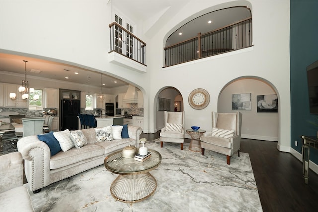 5502 Charlton Ridge Ln, Fulshear, TX 77441 - living area with dark wood-style floors, baseboards, arched walkways, a towering ceiling, and ornamental molding