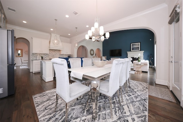 5502 Charlton Ridge Ln, Fulshear, TX 77441 - dining room featuring arched walkways, a chandelier, dark wood finished floors, ornamental molding, and recessed lighting