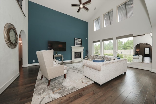 5502 Charlton Ridge Ln, Fulshear, TX 77441 - living area with high vaulted ceiling, arched walkways, a ceiling fan, and dark wood-type flooring