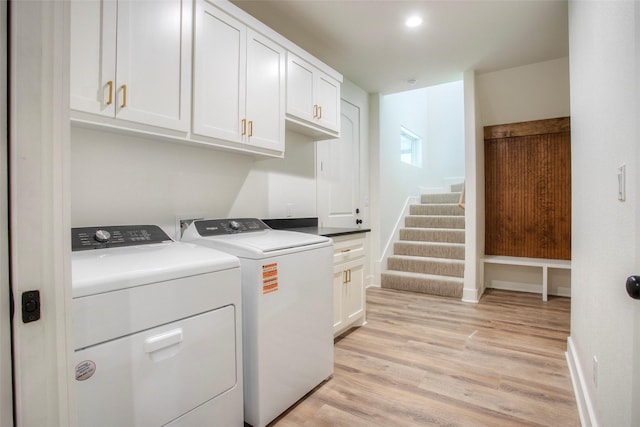 1973 Greentree Dr, Huntsville, TX 77340 - washroom featuring independent washer and dryer, cabinet space, and light wood-type flooring