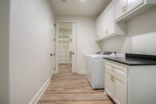 1973 Greentree Dr, Huntsville, TX 77340 - washroom featuring cabinet space, washer and clothes dryer, and light wood-type flooring