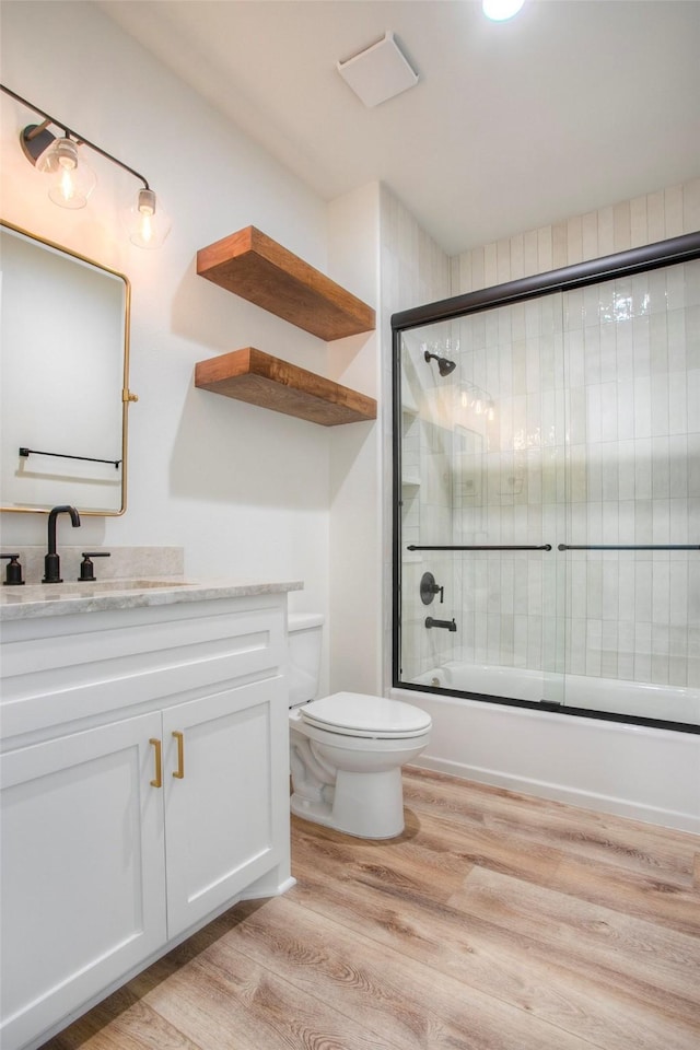 1973 Greentree Dr, Huntsville, TX 77340 - full bath with wood finished floors, vanity, and bath / shower combo with glass door