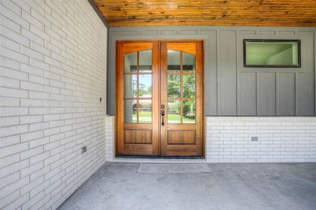 1973 Greentree Dr, Huntsville, TX 77340 - view of exterior entry featuring french doors, brick siding, and board and batten siding