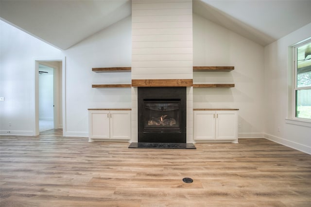 1973 Greentree Dr, Huntsville, TX 77340 - unfurnished living room with vaulted ceiling, light wood-style flooring, and a tiled fireplace