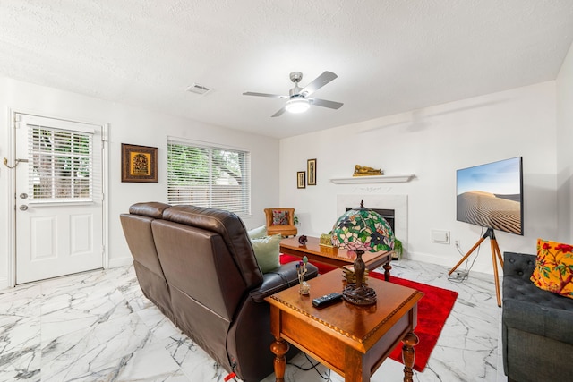 12114 Paddock Way, Houston, TX 77065 - living room with light marble finish floors, plenty of natural light, a ceiling fan, a fireplace, and a textured ceiling