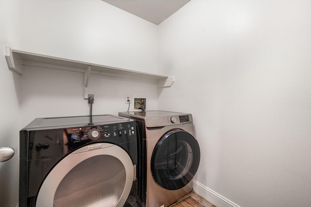 12114 Paddock Way, Houston, TX 77065 - laundry area with washing machine and clothes dryer, baseboards, and wood finished floors