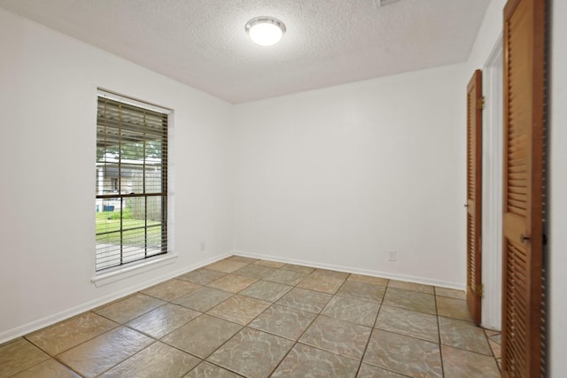1926 Klauke Ct, Rosenberg, TX 77471 - unfurnished room featuring a textured ceiling, baseboards, and tile patterned flooring