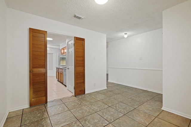 1926 Klauke Ct, Rosenberg, TX 77471 - unfurnished room with a textured ceiling, light tile patterned floors, and baseboards