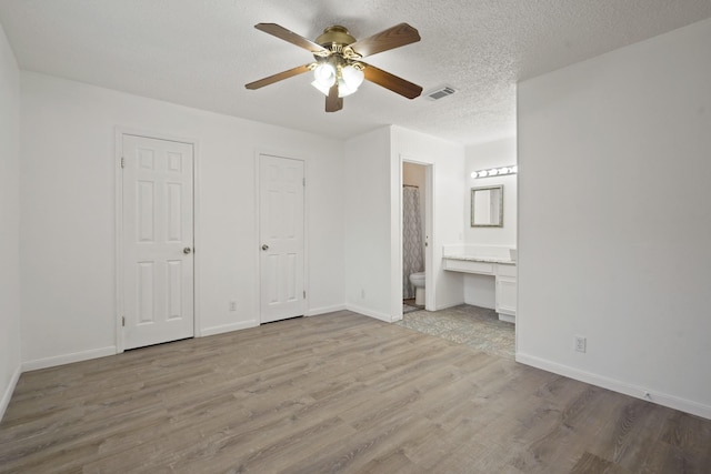 1926 Klauke Ct, Rosenberg, TX 77471 - unfurnished bedroom with wood finished floors, a desk, baseboards, ensuite bathroom, and a ceiling fan
