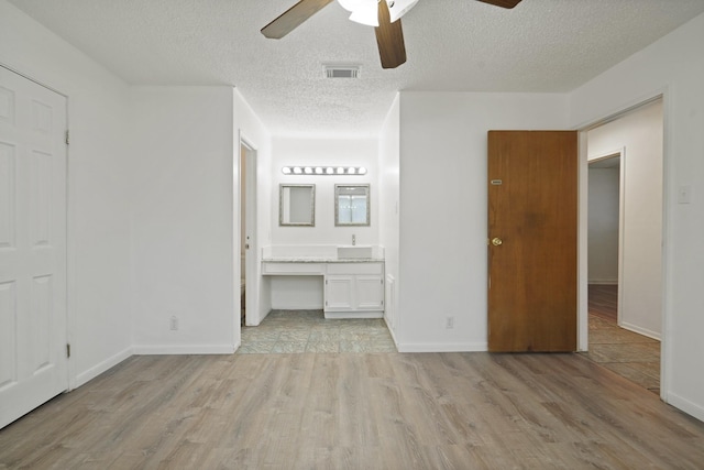 1926 Klauke Ct, Rosenberg, TX 77471 - unfurnished bedroom with light wood finished floors, a textured ceiling, baseboards, and a ceiling fan