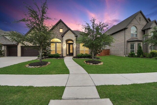 11626 Whitewave Bend Ct, Cypress, TX 77433 - french country style house featuring a front yard, driveway, brick siding, and a garage
