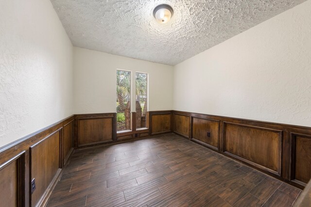 6131 Knollview Dr, Spring, TX 77389 - empty room featuring a textured ceiling, a wainscoted wall, dark wood finished floors, and a textured wall