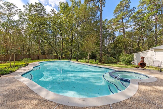 6131 Knollview Dr, Spring, TX 77389 - view of swimming pool featuring fence, a pool with connected hot tub, and view of scattered trees
