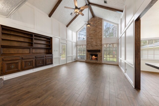 6131 Knollview Dr, Spring, TX 77389 - unfurnished living room featuring ceiling fan, beamed ceiling, a brick fireplace, high vaulted ceiling, and dark wood finished floors