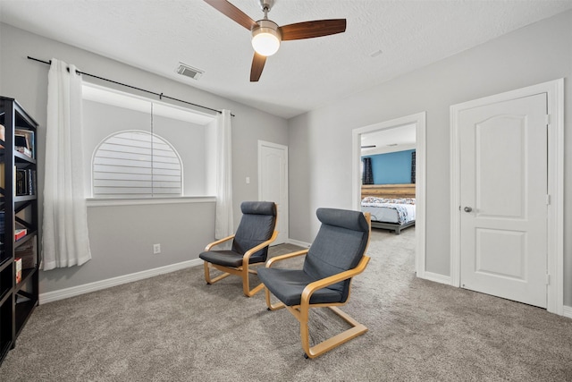 living area with carpet floors, a ceiling fan, a textured ceiling, and baseboards
