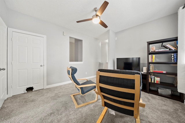 carpeted office space with ceiling fan and baseboards