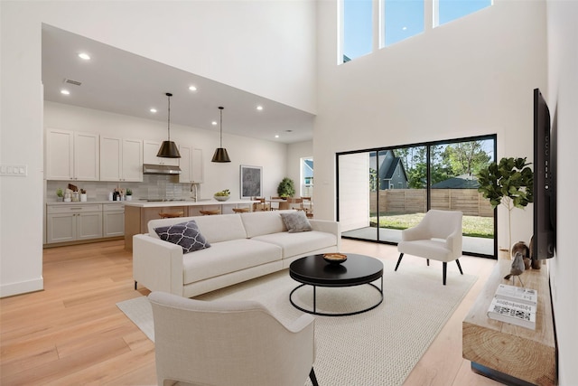 1420 Flamingo St, Conroe, TX 77385 - living room with light wood-style flooring, a towering ceiling, and recessed lighting