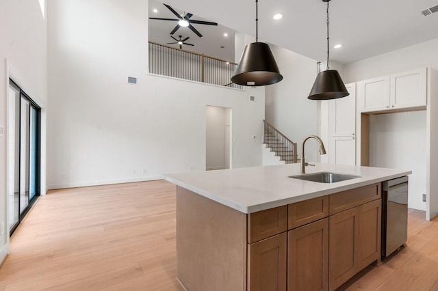 1420 Flamingo St, Conroe, TX 77385 - kitchen with a sink, stainless steel dishwasher, a high ceiling, ceiling fan, and light wood finished floors