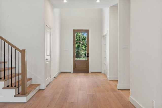 entryway with light wood-type flooring, stairway, recessed lighting, and baseboards