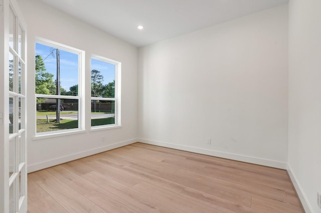 empty room featuring light wood-style flooring, baseboards, and recessed lighting