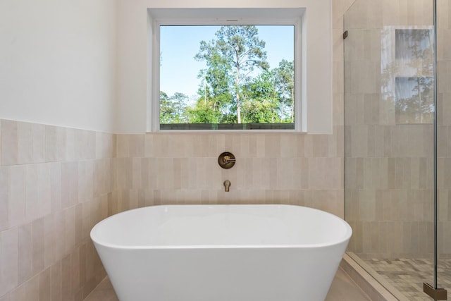 1420 Flamingo St, Conroe, TX 77385 - bathroom with tile walls, a freestanding bath, healthy amount of natural light, and tiled shower