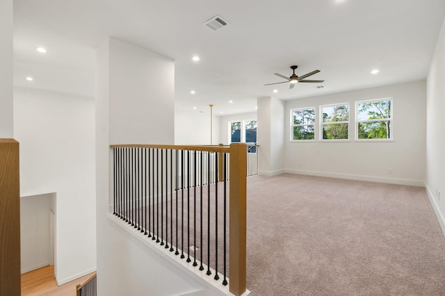 hall with an upstairs landing, recessed lighting, baseboards, and light carpet