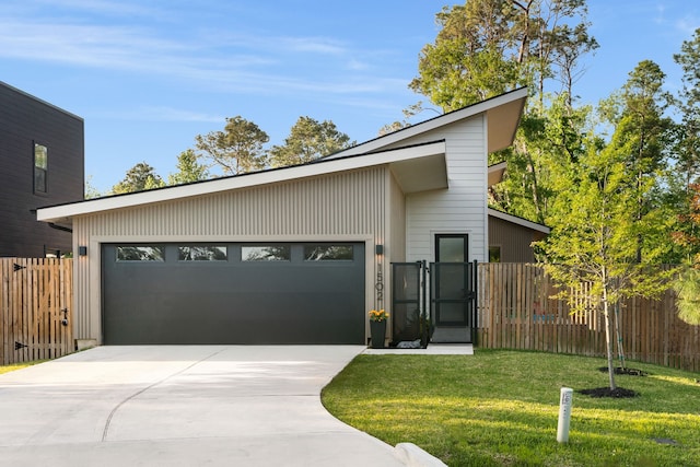 mid-century home featuring driveway, an attached garage, and a gate