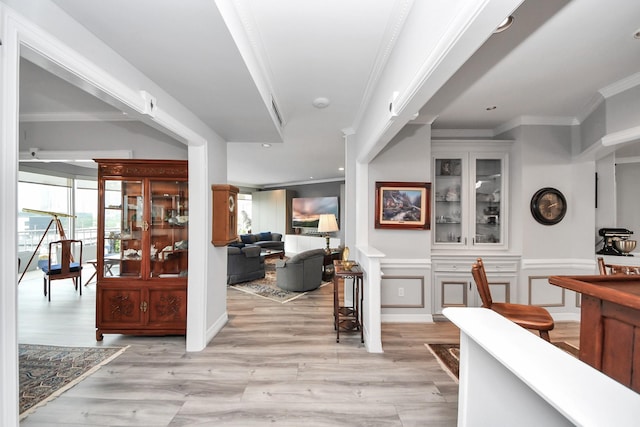 5050 Woodway Dr Unit 7L, Houston, TX 77056 - corridor featuring crown molding, plenty of natural light, light wood finished floors, a wainscoted wall, and a decorative wall